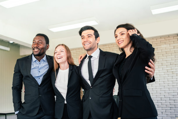 在办公室开会的时候，非洲商人和白人同事站在一起，心情愉快地看着摄像机。商务人员的多样性。图片下载