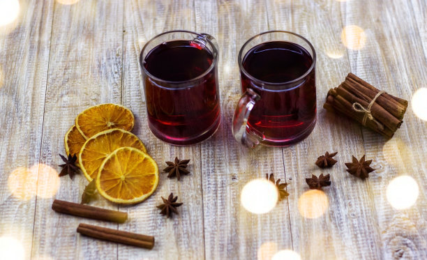 木制背景上的热葡萄酒和香料。图片下载