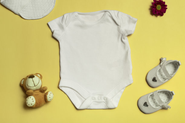 为设计和放置标志，广告的模型。白色婴儿紧身衣，俯视图，在黄色背景上模拟。图片下载