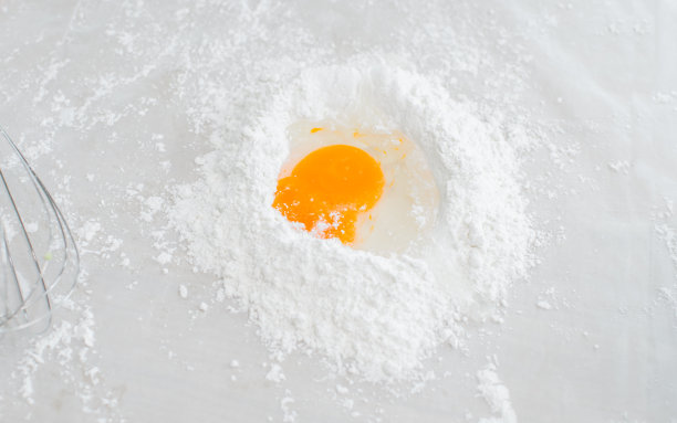 有选择地把生鸡蛋放在餐桌上和面粉面团一起烹饪，在家里的室内厨房里制作面包或牛角面包。图片下载