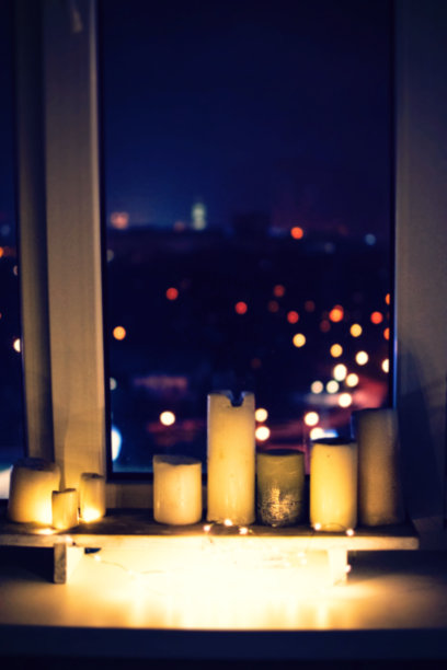 窗台背景上无聚焦的蜡烛，晚上有灯光和散景图片下载