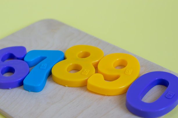 磁铁玩具数字和数学符号在木板上，在黄色背景。黄色，蓝色，紫色。一组从0到9的10个数字图片下载