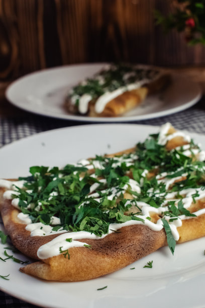 餐厅里盘子里有奶酪的薄饼。在咖啡馆吃早餐。一位妇女用一次性盘子吃煎饼当早餐。俯视图和垂直照片图片下载