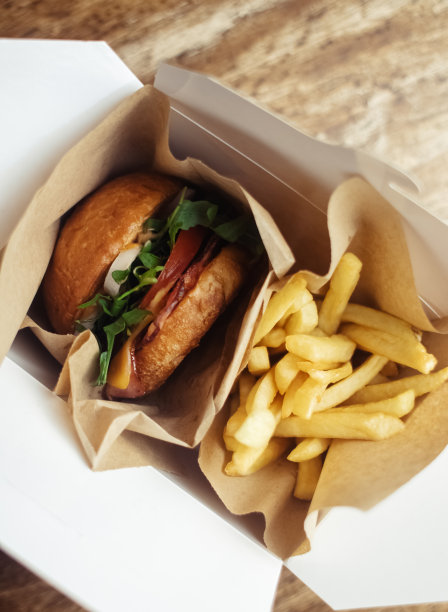 标准汉堡和炸薯条的特写镜头。餐馆或咖啡馆里的成人快餐。微距照片的汉堡原料与肉，奶酪和香草。为全家准备的环保汉堡图片下载