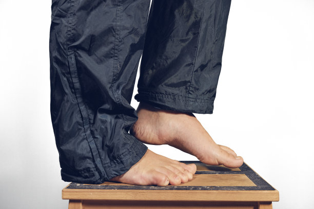 男脚赤脚站在椅子上做姿势图片下载