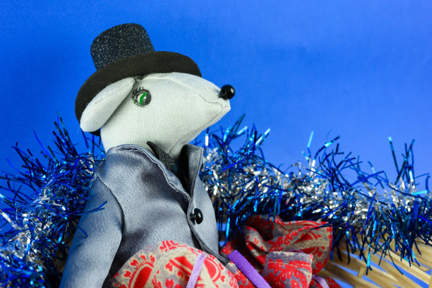 一只穿着夹克戴着帽子的玩具老鼠，背景是新年。图片下载