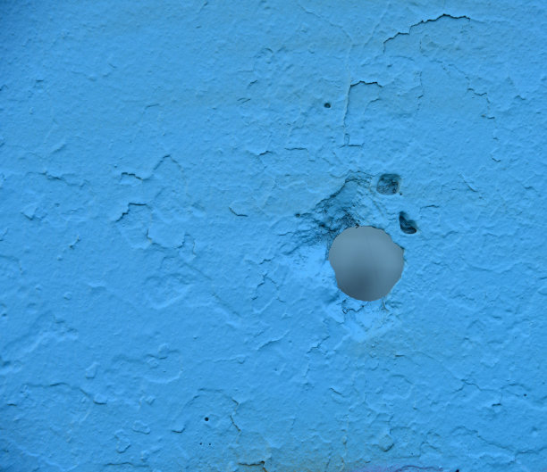 蓝色混凝土栅栏上的圆洞。图片下载