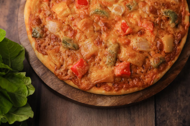 热烟披萨在木制的桌子与奶酪伸展，奶酪串与所有成分的近距离选择性聚焦和模糊图片下载