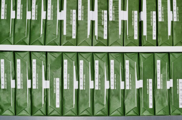 复制纸与通用品牌绿色包装堆叠成排。图片下载