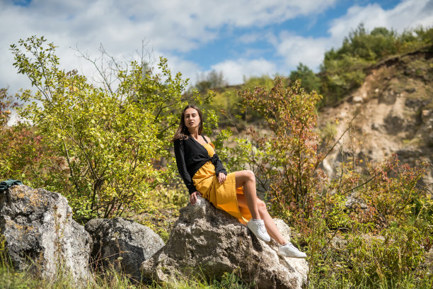 一个可爱的女人躺在采石场的大石头上图片下载