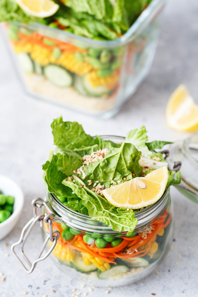 装有新鲜生蔬菜和粗麦粉的玻璃瓶。健康膳食准备-食谱准备照片。玻璃容器中的健康素食菜肴。减肥食物的概念。自制的罐子里的沙拉。图片下载