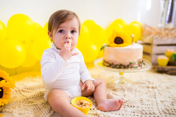 可爱的宝宝在吃蛋糕庆祝她的生日图片下载