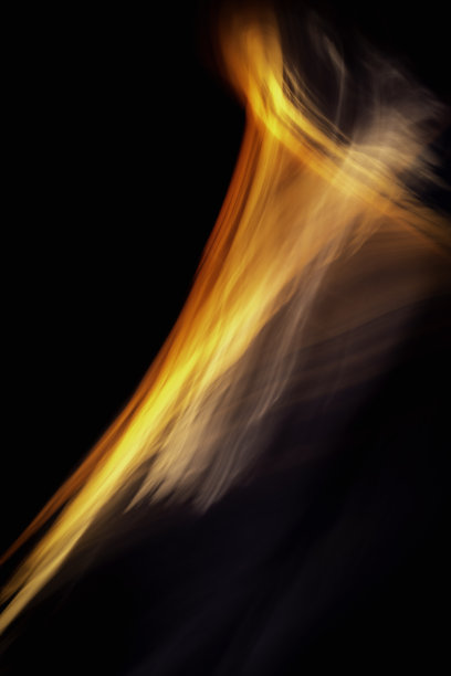 在最黑暗的夜晚升起火焰。红色和黄色的光迹在黑色背景上对角线弯曲。图片下载