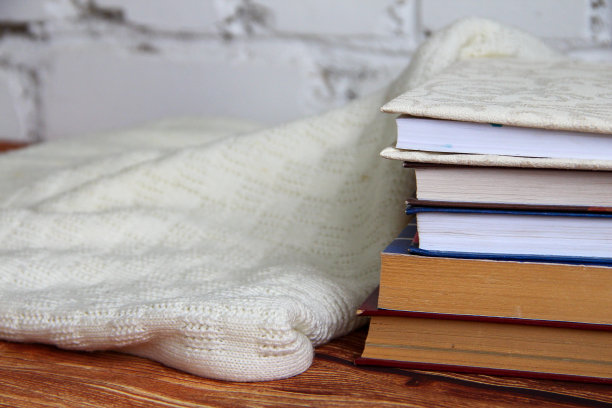 旁边有一堆书和一件舒适的毛衣图片下载