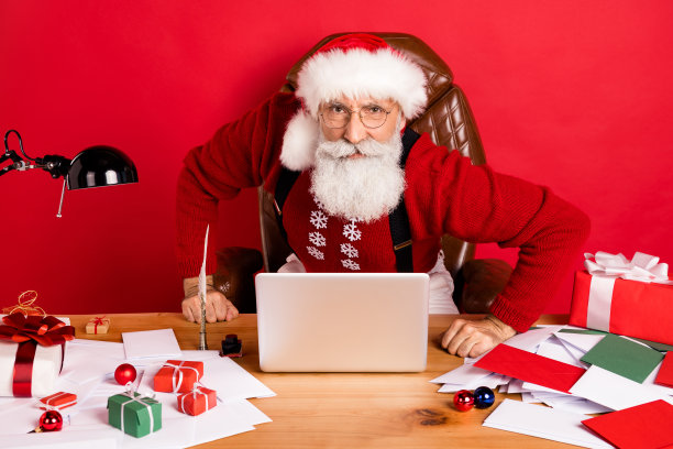 圣诞老人的照片不高兴的消极的愤怒的问题坐桌子电脑eve时间隔离在红色背景图片下载