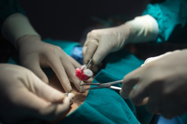 在医院里进行手术的手术室工作人员双手紧闭。图片下载