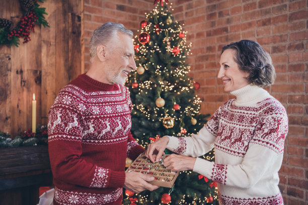 正对情侣在装修室内准备常青树传统穿鹿纹套头衫的照片图片下载