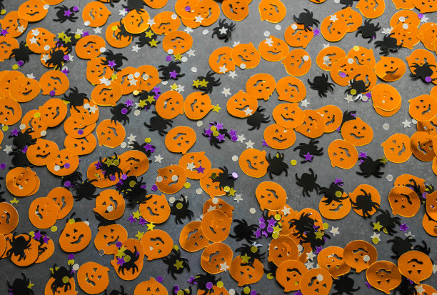 万圣节的背景:橙色南瓜、黑色蜘蛛和星星形状的五彩纸屑。本空间图片下载