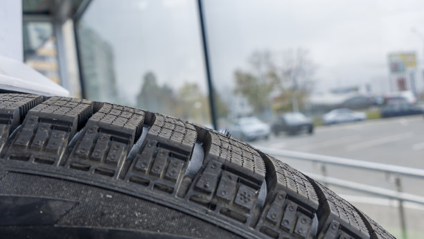 在商店的一个新轮胎的冬季胎面特写。雪道用汽车轮胎。有选择性的重点。图片下载