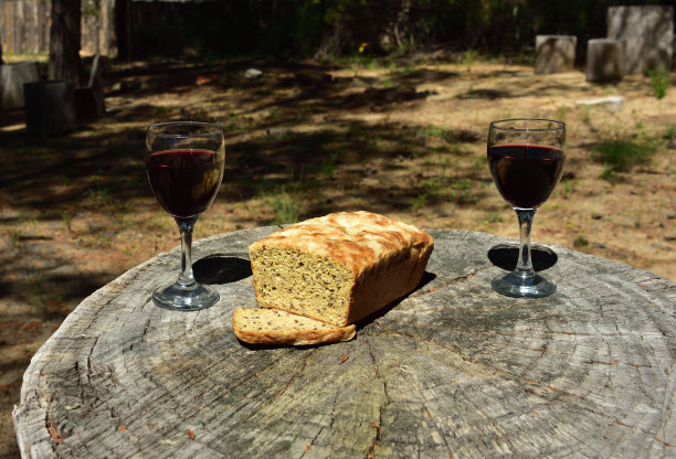 自制的面包和酒放在一个锯掉的树桩上，象征着美好的生活，在树林里野餐图片下载