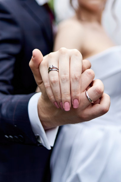 结婚戒指，复印空间。新婚夫妇的手上戴着结婚戒指。新婚夫妇，新娘和新郎，戴着戒指的手，特写图片下载