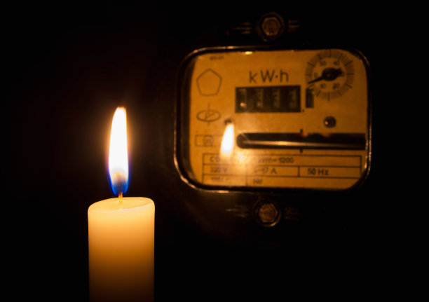 家里的旧电表附近，烛光在黑暗中闪烁。图片下载