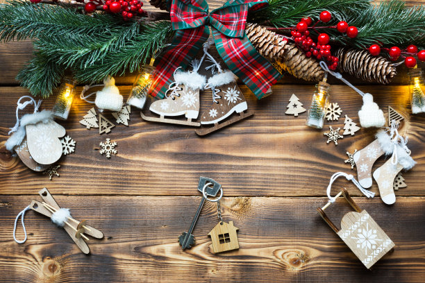 房子钥匙和钥匙链小屋在一个节日的生态友好，自然的背景与圣诞树。新年快乐——红色背景，礼物，贺卡。购买，建设，搬迁，抵押图片下载