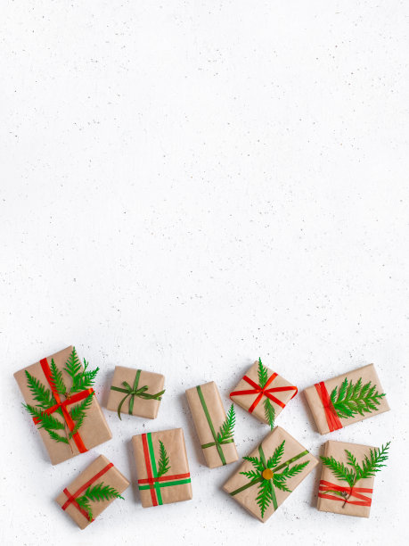 一组圣诞礼盒包在再生纸与丝带蝴蝶结白色石头背景。DIY手工制作的概念。顶视图,copyspace图片下载
