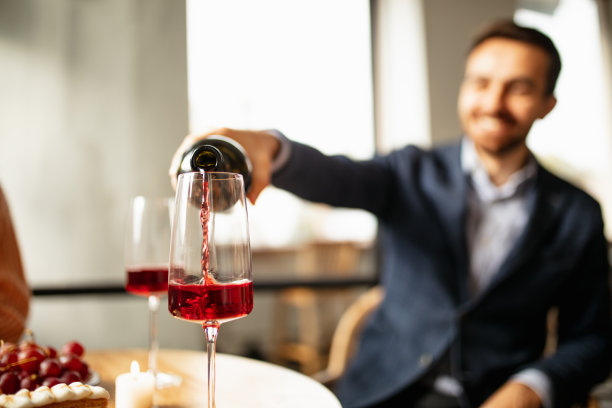 葡萄酒品尝。美食的乐趣。男人往杯子里倒美酒图片下载