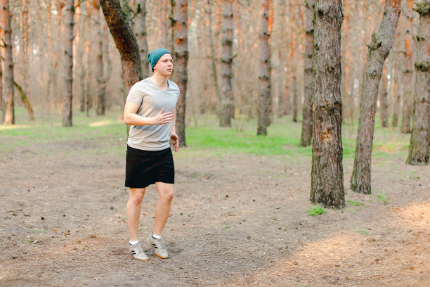 一个年轻人早晨在公园里慢跑和跑步图片下载