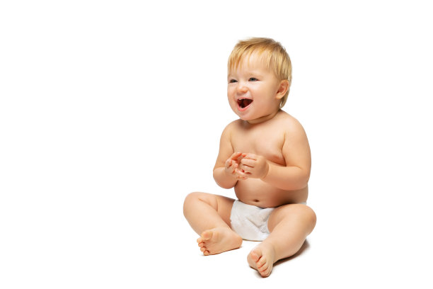 可爱的小男孩的肖像，婴儿在尿布坐孤立的白色工作室背景。富有感染力的笑声图片下载