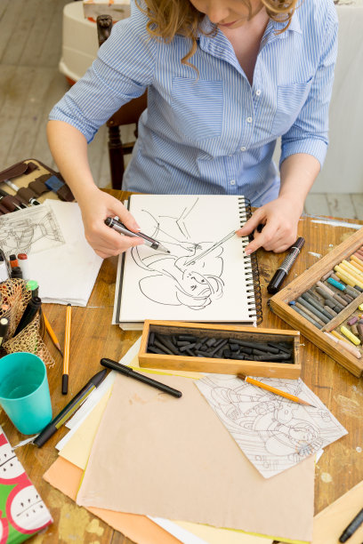 女孩用手绘笔在纸上画画。美丽的艺术家在画室里画这幅肖像图片下载