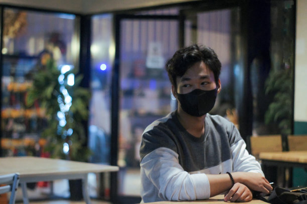 年轻人晚上坐在咖啡馆里戴着面具图片下载