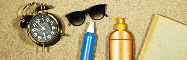 带奶瓶的旧书横幅，太阳眼镜和闹钟显示在沙滩上的12点，夏天的概念图片下载