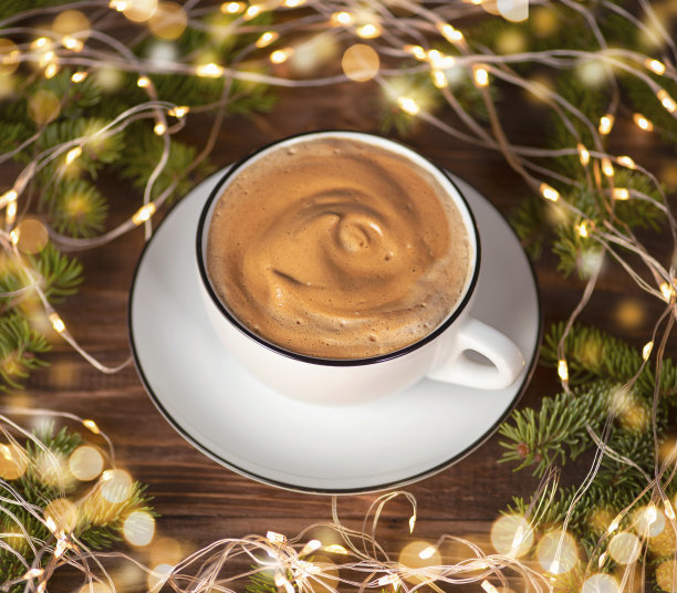 白色咖啡杯，杉木树枝，散焦在木制背景上。图片下载