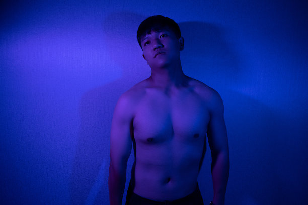 一个身强力壮的男人在紫光下裸露的肌肉图片下载