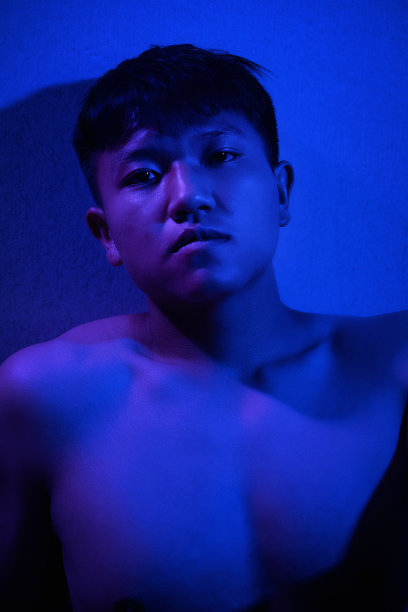 一个身强力壮的男人在紫光下裸露的肌肉图片下载