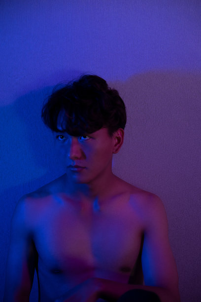 一个身强力壮的男人在紫光下裸露的肌肉图片下载