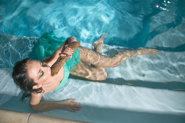 漂亮的年轻女孩，湿头发，蓝色裙子在游泳池。概念就是美和时尚。图片下载