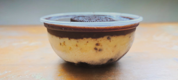 一杯冰淇淋，上面有融化的巧克力和一块饼干。图片下载