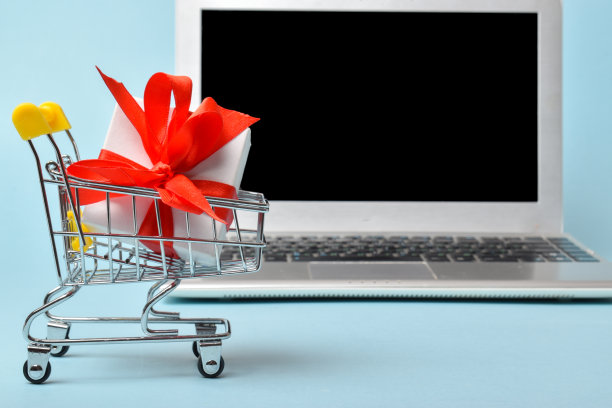 超市购物车，背景是笔记本电脑和礼物图片下载