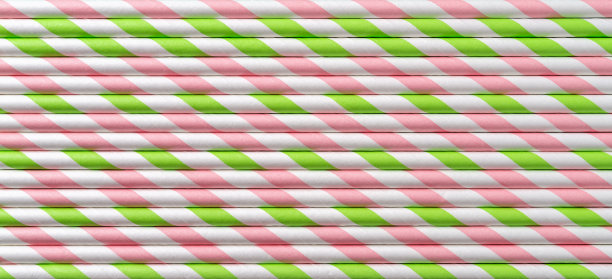 一次性粉红色条纹鸡尾酒吸管水平纹理。宏观背景的纸条纹饮酒管。零浪费环保多彩吸管派对理念。图片下载