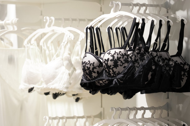 现代时尚的内衣店。内衣店里挂着一排黑白相间的胸罩。挂在衣架上的内衣在商店展示图片下载