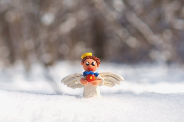 圣诞天使带着礼物在白雪覆盖的森林里。图片下载