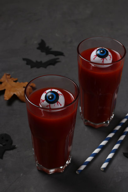 眼睛在玻璃与番茄鸡尾酒在黑暗的桌子上为秋季假日万圣节。特写镜头。垂直格式。图片下载