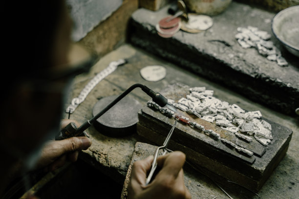 珠宝商在珠宝行业工作。用专业工具制作工艺首饰的桌面。近距离查看工具。银首饰。图片下载