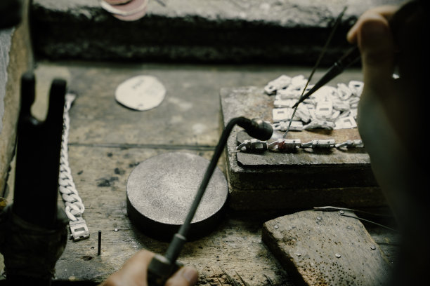 珠宝商在珠宝行业工作。用专业工具制作工艺首饰的桌面。近距离查看工具。银首饰。图片下载