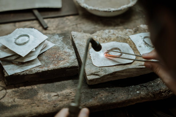 珠宝商在珠宝行业工作。用专业工具制作工艺首饰的桌面。近距离查看工具。银首饰。图片下载