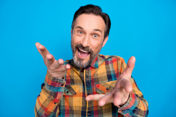 酷的深色头发的照片成熟的男人谈话穿黄色衬衫孤立在蓝色的背景图片下载