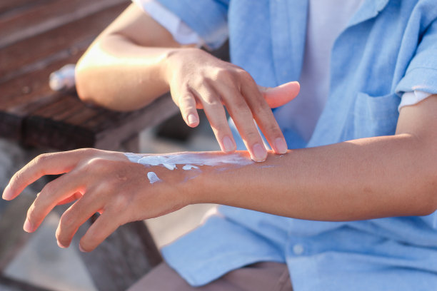 年轻人坐在户外使用防晒霜图片下载